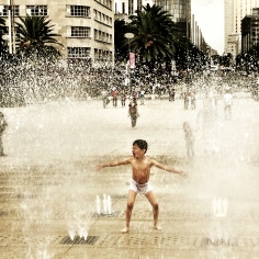 Boy playing in the fountain in from of Monumento de la Revolution, Mexico City
